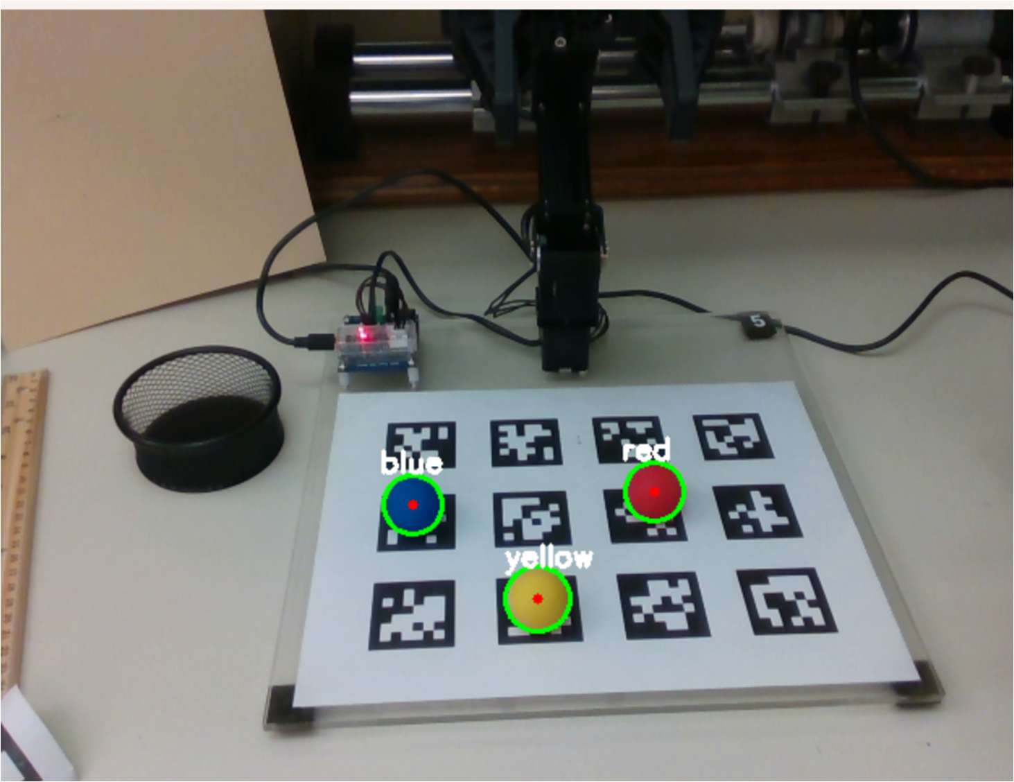 Camera view of coloured balls on a calibration board, each identified and circled by the colour detection routine.